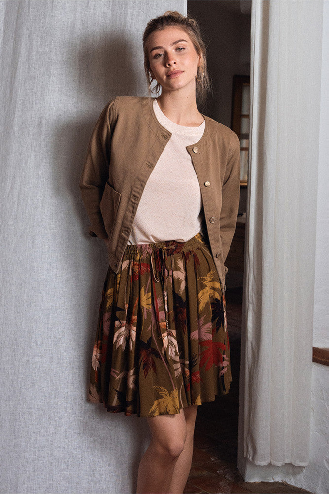 Gonna corta stampa palme Molly Bracken abbinata a t-shirt bianca e giacca beige